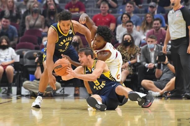Malcolm Brogdon and Brad Wanamaker of the Indiana Pacers fight Collin Sexton of the Cleveland Cavaliers for a loose ball during the first quarter at...