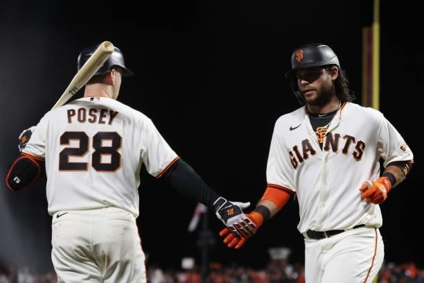 Brandon Crawford of the San Francisco Giants high fives Buster Posey after hitting a solo home run off Alex Vesia of the Los Angeles Dodgers during...