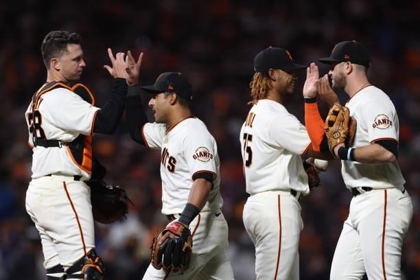 Buster Posey, Donovan Solano, Camilo Doval and Evan Longoria of the San Francisco Giants celebrate after defeating the Los Angeles Dodgers 4-0 in...
