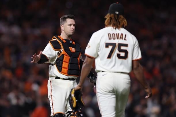 Camilo Doval of the San Francisco Giants celebrates with Buster Posey after the final out of Game 1 of the National League Division Series against...