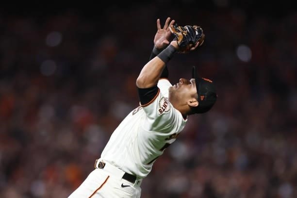Donovan Solano of the San Francisco Giants catches a fly ball against the Los Angeles Dodgers during the ninth inning of Game 1 of the National...