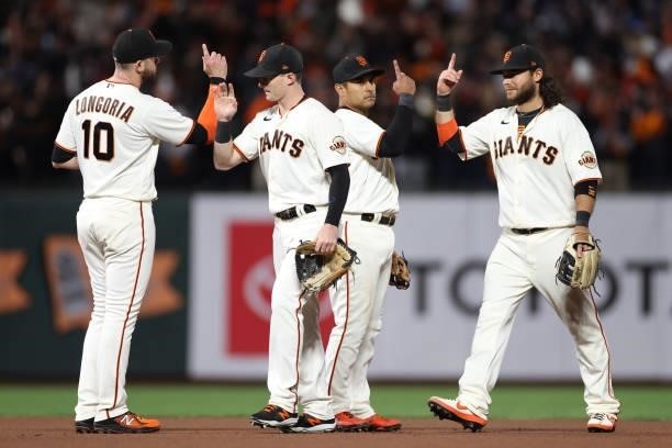 Evan Longoria, Mike Yastrzemski, Donovan Solano and Brandon Crawford of the San Francisco Giants celebrate after defeating the Los Angeles Dodgers...