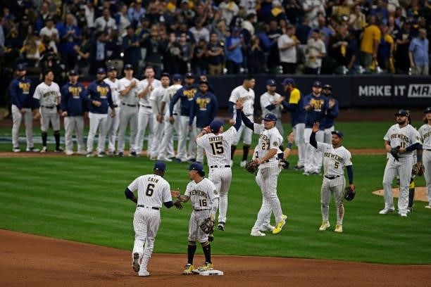 Willy Adames and several Brewers celebrate a win against the Atlanta Braves after Game One of the National League division series at American Family...