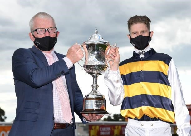 Trainer Mick Price and Jye McNeil pose with the trophy after I'm Thunderstruck won Race 9, the Hyland Race Colours Toorak Handicap, during Melbourne...