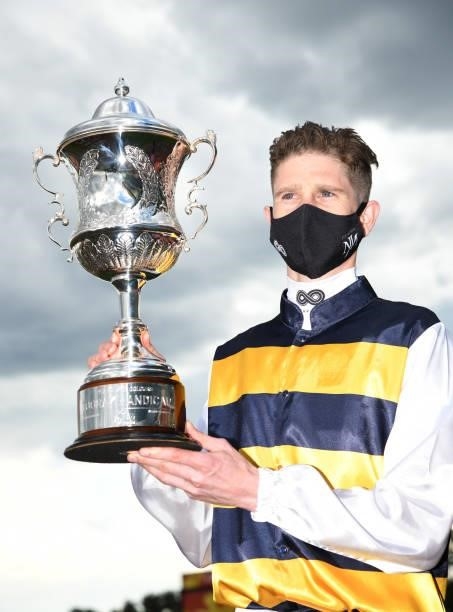 Jye McNeil poses with the trophy after riding I'm Thunderstruck to win Race 9, the Hyland Race Colours Toorak Handicap, during Melbourne Racing at...