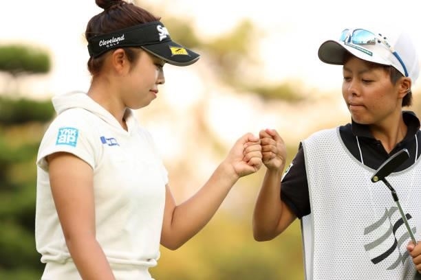 Miyuu Yamashita of Japan fist bumps with her caddie after holing out with the birdie on the 18th green during the second round of the Stanley Ladies...
