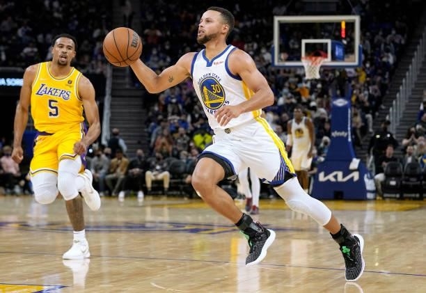 Stephen Curry of the Golden State Warriors drives towards the basket for a layup against the Los Angeles Lakers at Chase Center on October 08, 2021...