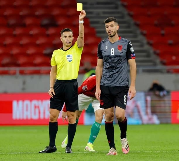 Referee Carlos del Cerro Grande shows a yellow card for Klaus Gjasula of Albania during the FIFA World Cup 2022 Qatar Qualifier match between Hungary...