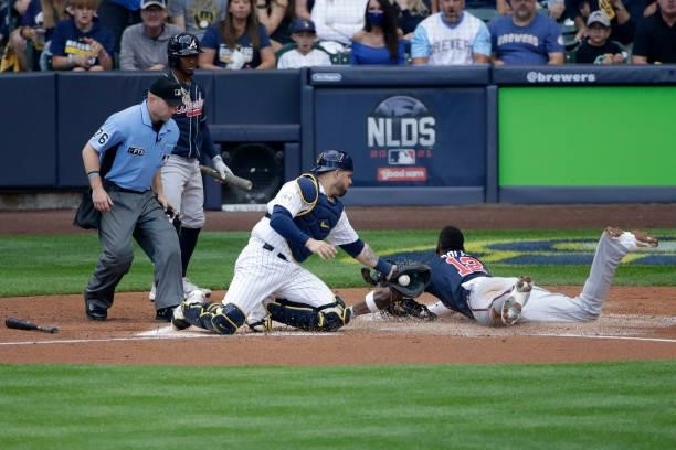 Jorge Soler of the Atlanta Braves is safe at home after avoiding a tag by Manny Pina of the Milwaukee Brewers in the third inning during game 2 of...