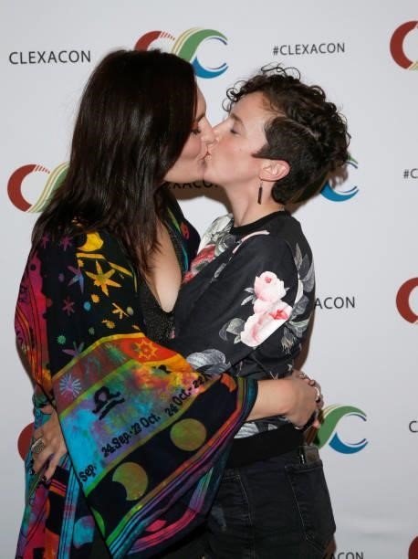 Actress Mary Chieffo and actor/writer Madi Goff kiss during the ClexaCon 2021 convention at the Tropicana Las Vegas on October 09, 2021 in Las Vegas,...