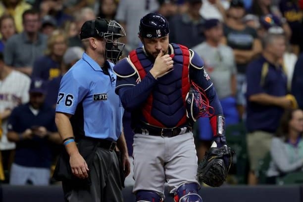 Travis d'Arnaud of the Atlanta Braves discusses a call with umpire Mike Muchlinski in the seventh inning during game 2 of the National League...
