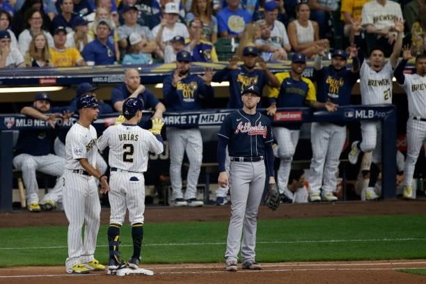 Luis Urias of the Milwaukee Brewers singles in the seventh inning and reacts towards the bench during game 2 of the National League Division Series...