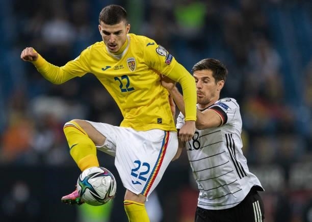 Valentin Mihaila of Romania is challenged by Jonas Hofmann of Germany during the 2022 FIFA World Cup Qualifier match between Germany and Romania at...
