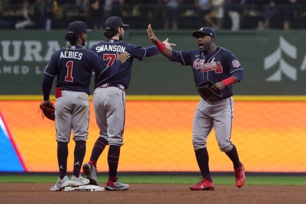 Guillermo Heredia of the Atlanta Braves celebrates with Ozzie Albies and Dansby Swanson of the Atlanta Braves after a win over the Milwaukee Brewers...
