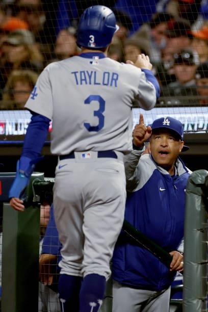 Chris Taylor and manager Dave Roberts of the Los Angeles Dodgers celebrate after Taylor scored a run in the sixth inning against the San Francisco...