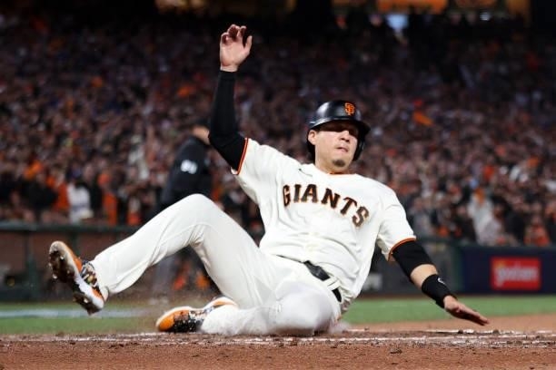 Wilmer Flores of the San Francisco Giants slides into home plate to score a run in the second inning against the Los Angeles Dodgers during Game 2 of...