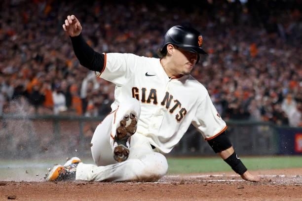 Wilmer Flores of the San Francisco Giants slides into home plate to score a run in the second inning against the Los Angeles Dodgers during Game 2 of...