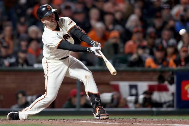 Buster Posey of the San Francisco Giants hits a single in the sixth inning against the Los Angeles Dodgers during Game 2 of the National League...