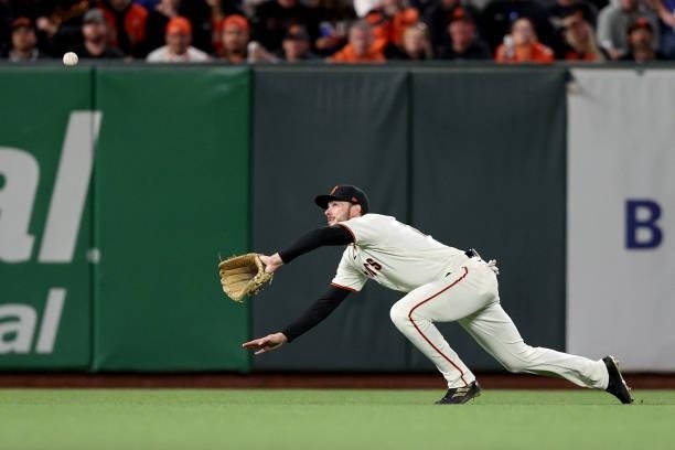 Kris Bryant of the San Francisco Giants dives to catch a fly ball in the seventh inning against the Los Angeles Dodgers during Game 2 of the National...