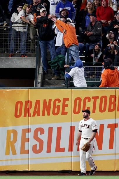 Fans attempt to catch a home run hit by Will Smith of the Los Angeles Dodgers in the eighth inning as Darin Ruf of the San Francisco Giants looks on...