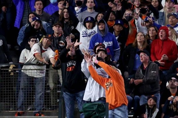 Fans attempt to catch a home run hit by Will Smith of the Los Angeles Dodgers in the eighth inning against the San Francisco Giants during Game 2 of...