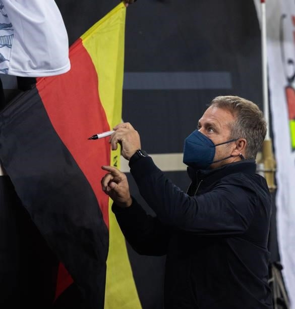Head coach Hansi Flick of Germany signs autographs during the 2022 FIFA World Cup Qualifier match between Germany and Romania at Imtech Arena on...