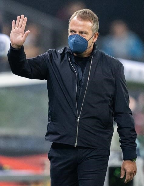 Head coach Hansi Flick of Germany with a face mask waves to his fans during the 2022 FIFA World Cup Qualifier match between Germany and Romania at...