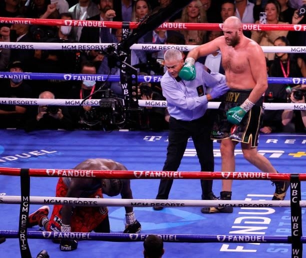 Referee Russell Mora moves Tyson Fury away from Deontay Wilder after Fury knocked Wilder down in the 10th round of their WBC heavyweight title fight...