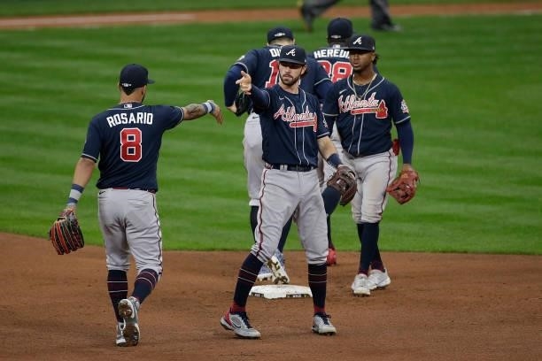 Dansby Swanson of the Atlanta Braves celebrates with teammates after game 2 of the National League Division Series at American Family Field on...