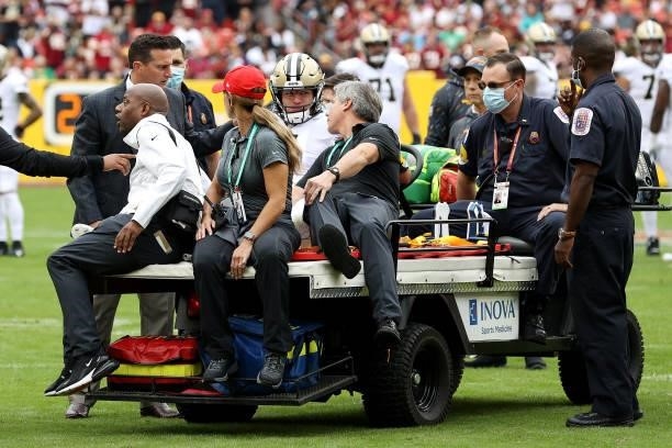 Taysom Hill of the New Orleans Saints is carted off the field during the first half against the Washington Football Team at FedExField on October 10,...
