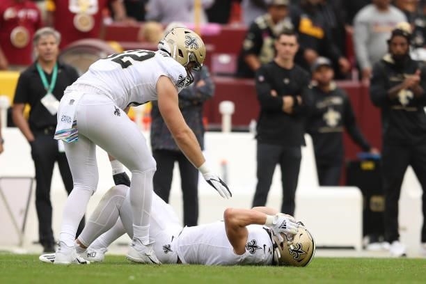 Taysom Hill of the New Orleans Saints lays on the field after being injured during the first half against the Washington Football Team at FedExField...