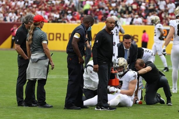 Medical staff check on Taysom Hill of the New Orleans Saints during the first half against the Washington Football Team at FedExField on October 10,...