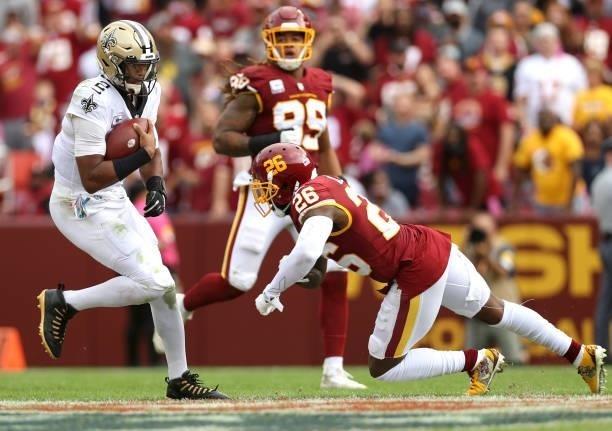 Jameis Winston of the New Orleans Saints runs with the ball as Landon Collins of the Washington Football Team defends during the second half at...