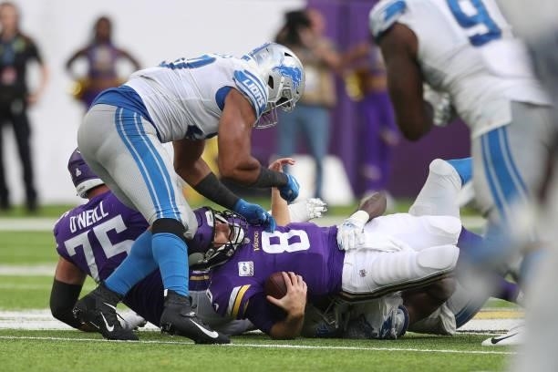 Kirk Cousins of the Minnesota Vikings is sacked by Charles Harris of the Detroit Lions during the fourth quarter at U.S. Bank Stadium on October 10,...