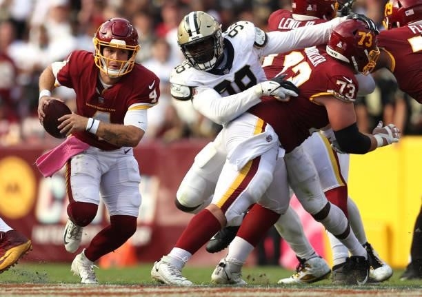 Taylor Heinicke of the Washington Football Team is pressured by Carl Granderson of the New Orleans Saints during the second half at FedExField on...