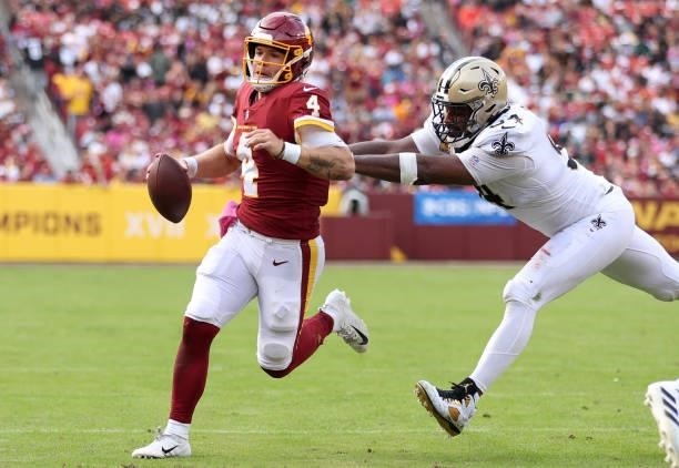 Taylor Heinicke of the Washington Football Team is pressured by Cameron Jordan of the New Orleans Saints during the second half at FedExField on...