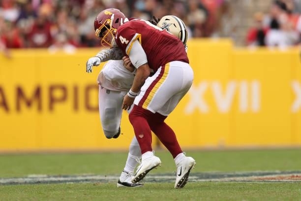 Taylor Heinicke of the Washington Football Team is hit during the second half against the New Orleans Saints at FedExField on October 10, 2021 in...