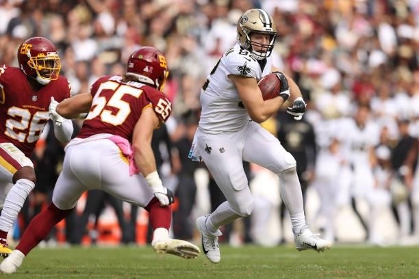 Adam Trautman of the New Orleans Saints runs with the ball as Cole Holcomb of the Washington Football Team defends during the second half at...