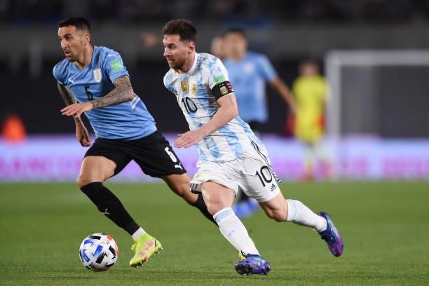Lionel Messi of Argentina fights for the ball with Matias Vecino of Uruguay during a match between Argentina and Uruguay as part of South American...