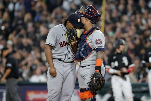 Martin Maldonado of the Houston Astros talks with Luis Garcia of the Houston Astros in the first inning during game 3 of the American League Division...