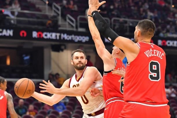 Kevin Love of the Cleveland Cavaliers passes around Alex Caruso and Nikola Vucevic of the Chicago Bulls during the second quarter at Rocket Mortgage...