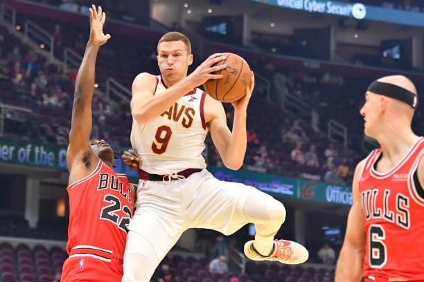 Dylan Windler of the Cleveland Cavaliers grabs a rebound over Alize Johnson and Alex Caruso of the Chicago Bulls during the first quarter at Rocket...