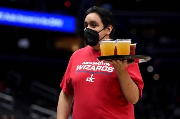 Server carries a tray of beer at the game between the Washington Wizards and the New York Knicks at Capital One Arena on October 09, 2021 in...