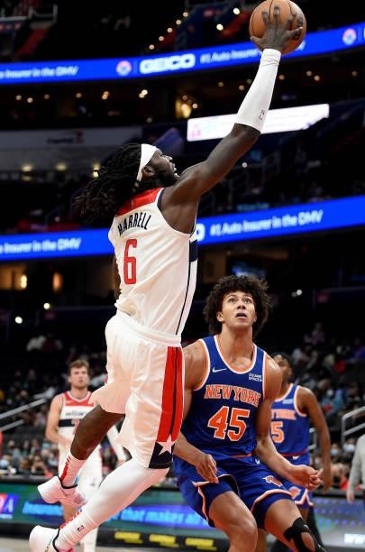 Montrezl Harrell of the Washington Wizards handles the ball against Jericho Sims of the New York Knicks at Capital One Arena on October 09, 2021 in...