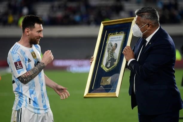 Lionel Messi receives a distinction from Claudio Tapia President of AFA during a match between Argentina and Uruguay as part of South American...