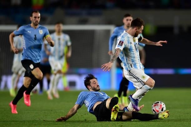 Lionel Messi of Argentina fights for the ball with Matias Viña of Uruguay during a match between Argentina and Uruguay as part of South American...