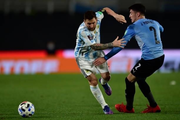 Lionel Messi of Argentina fights for the ball with Joaquin Piquerez of Uruguay during a match between Argentina and Uruguay as part of South American...