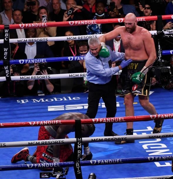 Deontay Wilder falls to the floor as Tyson Fury stands up during the World Heavyweight Championship III trilogy fight at T-Mobile Arena Saturday...
