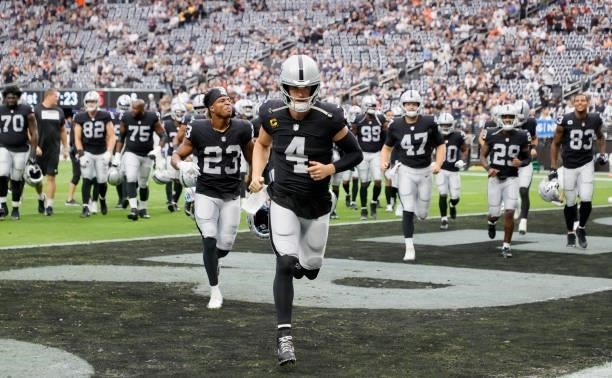 The Las Vegas Raiders, including quarterback Derek Carr and running back Kenyan Drake, walk off the field after warmups before a game against the...