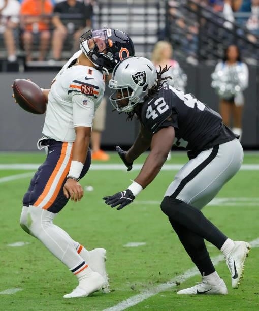 Quarterback Justin Fields of the Chicago Bears turns away from inside linebacker Cory Littleton of the Las Vegas Raiders as a play is called dead for...